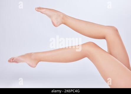 Primo a colpire il pavimento. gambe di donne irriconoscibili in studio su uno sfondo bianco. Foto Stock