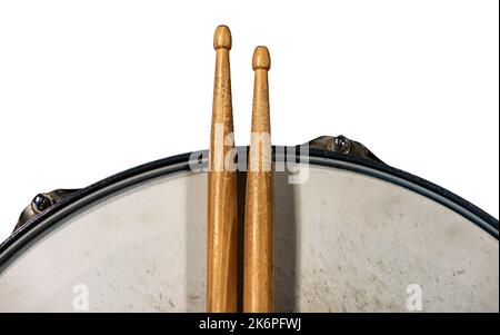 Primo piano di due bacchette di legno e un vecchio tamburo metallico, isolato su sfondo bianco, fotografia. Strumento a percussione. Foto Stock