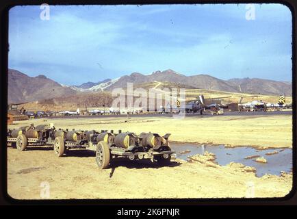 Vista frontale destra di tre quarti di una Repubblica F-84B Thunderjet (s/n 46-659) recante le marcature del 8th Fighter Bomber Squadron (FBS), 49th Fighter Bomber Group (FBG), da qualche parte in Corea. Accanto ad essa si trova un'altra Repubblica F-84B Thunderjet (s/n 46-613). Sullo sfondo, sono visibili altri quattro F-84, due dei quali recano le marcature della 310th FBS, 58th FBG. In primo piano ci sono diversi carri che trasportano bombe. Foto Stock