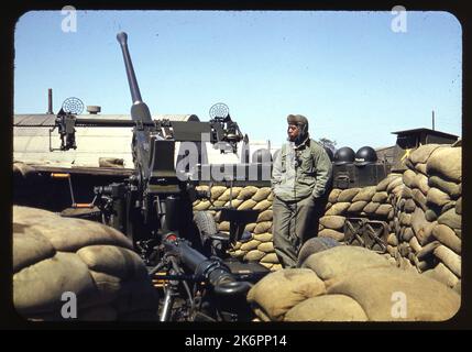 Vista posteriore sinistra di tre quarti di una pistola antiaerea Bofors da 40 mm in un'area in cartongesso da qualche parte in Corea. Accanto ad esso si trova un equipaggio. Foto Stock