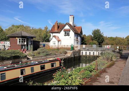 I custodi della serratura e della serratura di Goring si affacciano sul fiume Tamigi con il narrowboat che attraversa la serratura Foto Stock