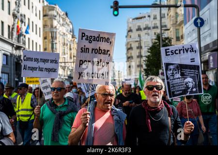 Madrid, Spagna. 15th Ott 2022. Le persone che trasportano cartelloni durante una manifestazione in cui migliaia di pensionati provenienti da tutta la Spagna hanno preso le strade per chiedere un 'IPC (Indice dei prezzi al consumo) in stipendi e pensioni?. I pensionati chiedono che le pensioni minime corrispondano al 60 per cento del salario minimo. Pensionati, unioni e cittadini hanno dimostrato attraverso il centro della città gridando slogan contro il governo, minacciando con uno sciopero generale, e chiedendo la non privatizzazione dei servizi pubblici. Credit: Marcos del Mazo/Alamy Live News Foto Stock