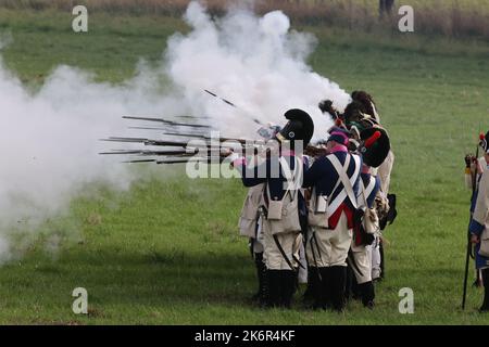 07 ottobre 2022, Turingia, cospeda: Gli artisti in uniformi d'epoca si esibiscono in un evento che segna il 216th° anniversario della battaglia prussiano-francese di Jena sullo storico campo di battaglia del 1806 in un campo vicino a cospeda. Diverse centinaia di partecipanti, tra cui alcuni provenienti dagli Stati Uniti, stanno rifacendo parte della doppia battaglia di Jena e Auerstedt. Durante la battaglia, le truppe francesi sotto Napoleone Bonaparte avevano schiacciato l'esercito prussiano-sassone il 14 ottobre 1806. Foto: Bodo Schackow/dpa Foto Stock