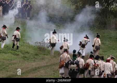 07 ottobre 2022, Turingia, cospeda: Gli artisti in uniformi d'epoca si esibiscono in un evento che segna il 216th° anniversario della battaglia prussiano-francese di Jena sullo storico campo di battaglia del 1806 in un campo vicino a cospeda. Diverse centinaia di partecipanti, tra cui alcuni provenienti dagli Stati Uniti, stanno rifacendo parte della doppia battaglia di Jena e Auerstedt. Durante la battaglia, le truppe francesi sotto Napoleone Bonaparte avevano schiacciato l'esercito prussiano-sassone il 14 ottobre 1806. Foto: Bodo Schackow/dpa Foto Stock