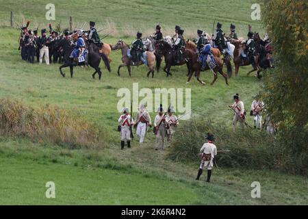 07 ottobre 2022, Turingia, cospeda: Gli artisti in uniformi d'epoca si esibiscono in un evento che segna il 216th° anniversario della battaglia prussiano-francese di Jena sullo storico campo di battaglia del 1806 in un campo vicino a cospeda. Diverse centinaia di partecipanti, tra cui alcuni provenienti dagli Stati Uniti, stanno rifacendo parte della doppia battaglia di Jena e Auerstedt. Durante la battaglia, le truppe francesi sotto Napoleone Bonaparte avevano schiacciato l'esercito prussiano-sassone il 14 ottobre 1806. Foto: Bodo Schackow/dpa Foto Stock