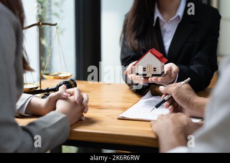 felice coppia marito moglie firma contratto di affitto a riunione con il realtor o proprietario, primo acquisto di proprietà, ipoteca e concetto di proprietà di prestito Foto Stock