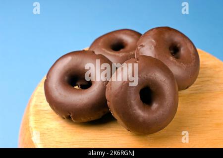 Mini ciambelle al cioccolato fondente molto dolce per uno spuntino. Foto Stock