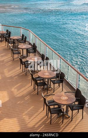 Mobili da esterno sulla nave da crociera. Tavoli e sedie vuoti sul ponte. Foto Stock