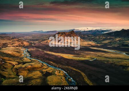 Vista aerea del cratere vulcanico tra il campo di lava e il fiume che scorre * al tramonto nelle Highlands islandesi in estate Foto Stock