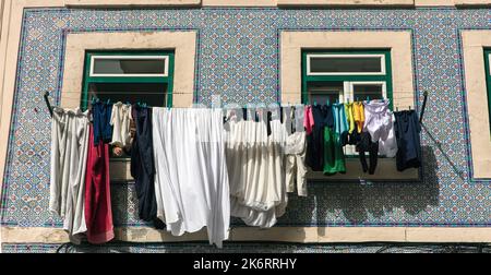 Lavanderia appeso ad asciugare su linee di abbigliamento fuori finestre a Bario Alto, Lisbona, Portogallo Foto Stock