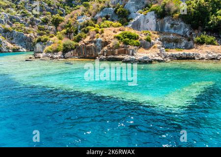 Costa dell'isola di Kekova con strutture sottomarine visibili della città di Sunken, nella provincia di Antalya, in Turchia. Le rovine sommerse si riferiscono a Dolchiste, an A. Foto Stock