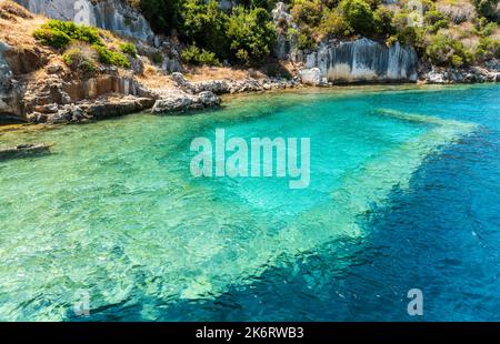 Costa dell'isola di Kekova con strutture sottomarine visibili della città di Sunken, nella provincia di Antalya, in Turchia. Le rovine sommerse si riferiscono a Dolchiste, an A. Foto Stock