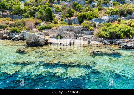 Costa dell'isola di Kekova con strutture parzialmente sommerse della città di Sunken, nella provincia di Antalya della Turchia. Le rovine sommerse si riferiscono a Dolchiste, un anc Foto Stock