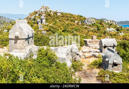 Paesaggio montano con tombe sparse sarcofago Licia vicino al villaggio di Kalekoy nella regione di Kekova nella provincia di Antalya in Turchia. Foto Stock