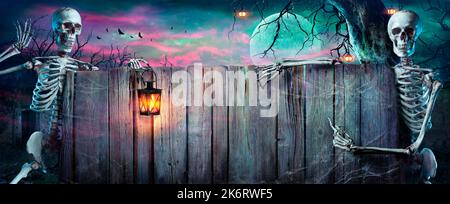 Halloween Party - scheletri con banner in legno nelle notti di Spooky Foto Stock