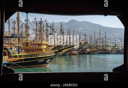 Alanya, Turchia – 19 agosto 2021. Vista incorniciata delle barche da crociera di escursione ad Alanya, Turchia, dall'apertura in un ponte di nave di legno. Foto Stock