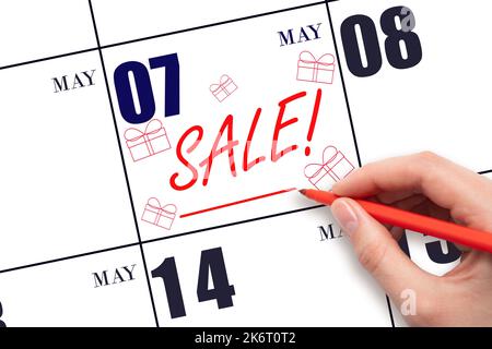 7th° giorno di maggio. Scrittura a mano testo VENDITA e disegno scatole regalo in data di calendario 7 maggio. Promemoria per gli acquisti. Shopping online. Mese di primavera, giorno del yea Foto Stock