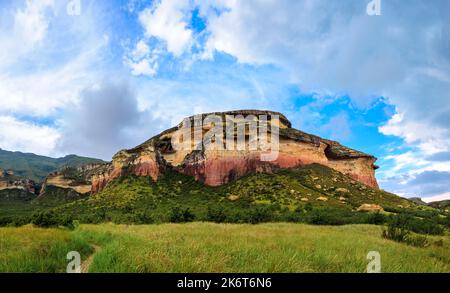 Pianure erbose sotto Mushroom Rock, un affioramento di arenaria colorata nel Golden Gate Highlands National Park. Si tratta di una riserva naturale vicino al popolare Foto Stock