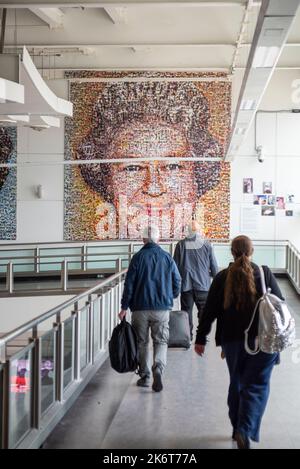 Il mosaico del Monarca del popolo. Illustrazione della regina Elisabetta II creata da piccole fotografie esposte all'aeroporto Gatwick di Londra, Regno Unito. Passeggeri in arrivo Foto Stock