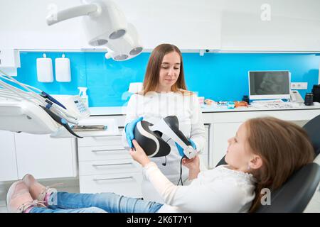 Stomatologo preparazione del paziente per l'esame dei denti utilizzando la tecnologia moderna Foto Stock