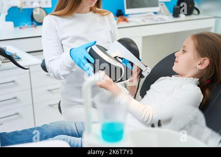 Pedodontist che prepara il bambino all'esame dei denti utilizzando la tecnologia moderna Foto Stock