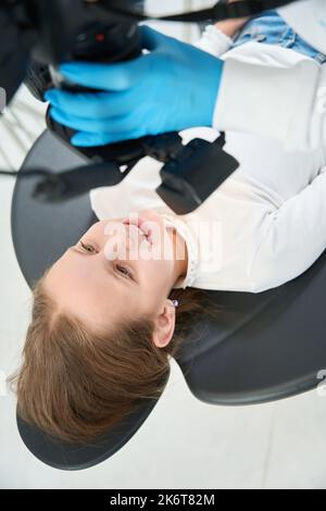 Pedodontist scattare foto extraorali di piccolo paziente sorridente prima del trattamento Foto Stock