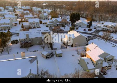 Dopo le nevicate, un complesso residenziale cittadino americano si trova vicino a una piccola strada residenziale fluviale in un paesaggio invernale innevato Foto Stock