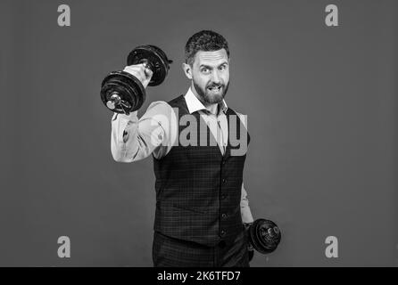 Uomo forte uomo d'affari fare dumbbell workout sfondo rosso, forza di business Foto Stock