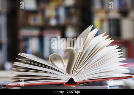 Libro con le sue pagine che si modellano come cuore Foto Stock