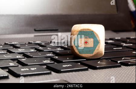 Cubo di legno con un simbolo medico angolo piatto Lay, concetto: Assicurazione sanitaria famiglia covid-2019 epidemia, gestione proteggere l'assistenza sanitaria a un virus, interni Foto Stock