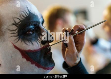 PRODUZIONE - 15 ottobre 2022, Hesse, Mühltal: Un make-up artista trasforma un performer in un clown horror. Frankenstein Castle ospita l'evento di Halloween dal 1977, quest'anno per il 43rd° ottobre (21 novembre). 6, 2022). Durante una prova di vestito, l'organizzatore ha attraversato l'evento spaventoso con un pubblico speciale. Foto: Andreas Arnold/dpa Credit: dpa picture Alliance/Alamy Live News Foto Stock