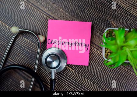 Concetto di cardiomiopatia scrivere su foglietti adesivi con stetoscopio isolato su tavola di legno. Foto Stock