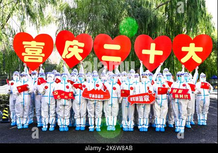 HOHHOT, CINA - 16 OTTOBRE 2022 - i volontari del Partito della Comunità e il personale medico scattano una foto di gruppo creativa di 'Benvenuti al 20th Congresso di Foto Stock