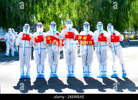 HOHHOT, CINA - 16 OTTOBRE 2022 - i volontari del Partito della Comunità e il personale medico scattano una foto di gruppo creativa di 'Benvenuti al 20th Congresso di Foto Stock