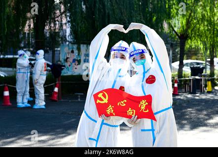 HOHHOT, CINA - 16 OTTOBRE 2022 - i volontari del Partito della Comunità e il personale medico scattano una foto di gruppo creativa di 'Benvenuti al 20th Congresso di Foto Stock