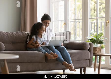 La mamma indiana e la bambina amano trascorrere il tempo libero utilizzando il computer portatile Foto Stock