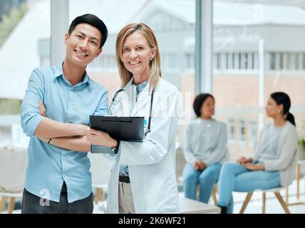 È un combattente. un medico maturo e il suo paziente discutono i suoi ultimi risultati in sala d'attesa. Foto Stock