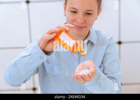 giovane donna che versa pillole da imballaggio di droga prescrizione Foto Stock