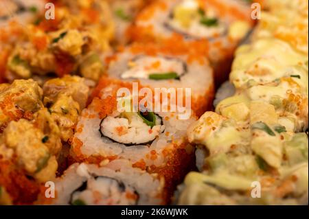 Un set di diversi tipi di rotoli in una scatola. Vista dall'alto di varie porzioni di panini vegetariani e di pesce. Primo piano, messa a fuoco selettiva. Foto Stock