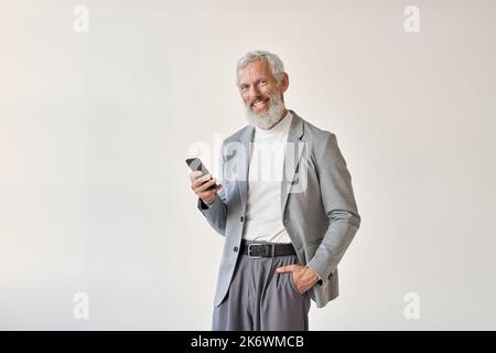 Un vecchio uomo d'affari sorridente che utilizza un telefono cellulare isolato su bianco. Foto Stock