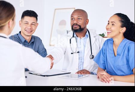 Youre ufficialmente parte del team. due medici che scuotono le mani in una clinica. Foto Stock