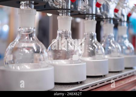Attrezzatura da laboratorio - fiale di vetro vuote sul mantello riscaldante in fila Foto Stock