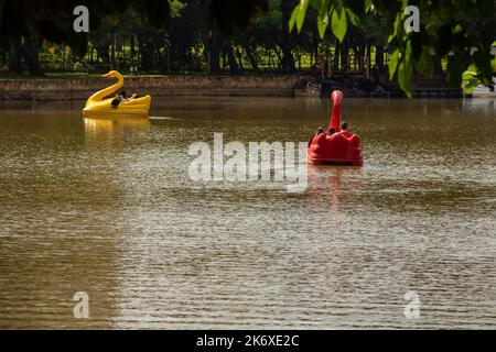 Goiânia, Goias, Brasile – 12 ottobre 2022: Due colorate barche a remi sul lago Roses visto attraverso gli alberi del parco. Foto Stock