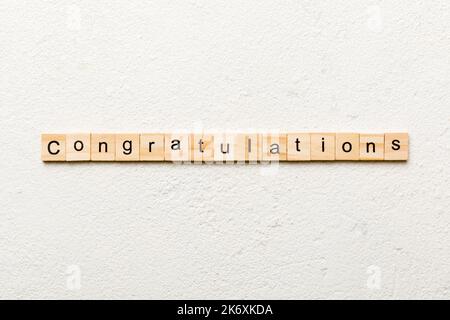 congratulazioni parola scritta su legno blocco. complimenti testo su cemento tavolo per la vostra desing, concetto. Foto Stock