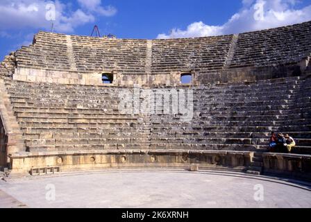 Parte del vecchio teatro romano sud, Jerash, Giordania con alcune persone sedute ai posti a sedere Foto Stock
