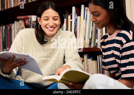 Stavano andando schiacciare questo compito. due giovani studentesse studentesche insieme in una biblioteca all'università. Foto Stock