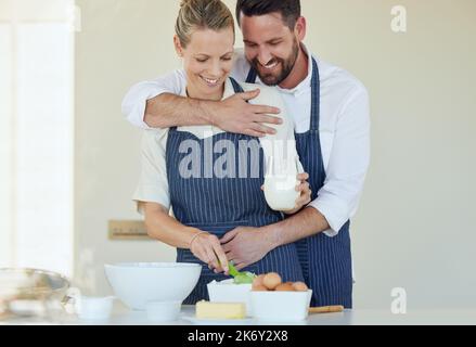 La cucina è la nostra cosa preferita da fare insieme. una giovane coppia che cucinava insieme a casa. Foto Stock