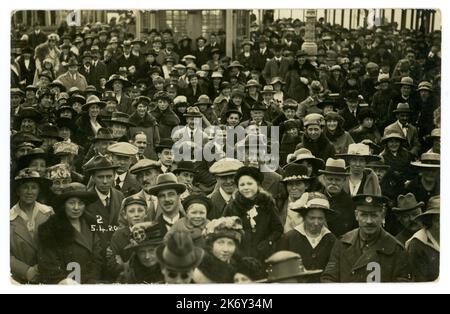 La folla originaria delle vacanze della classe operaia degli anni '1920 risale al 5 aprile 1920, località balneare britannica, con molti personaggi e mode, tra cui cappellini piatti e cappelli homburg. Foto retro del mare del Regno Unito. Foto Stock