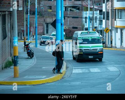 Puno, Perù - 27 2022 luglio: Uomo peruviano in attesa del bus pubblico sul viale Foto Stock