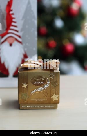 Espoo, Finlandia, 2020 dicembre: Confezione regalo decorativa d'oro riempita con palle Lindt Lindor - cioccolato svizzero di lusso perfetto per Natale e per divertirsi. Foto Stock